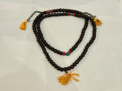 a close up of a beaded necklace with a tassel