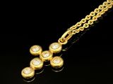 une image représentant un pendentif en forme de croix en or suspendu à une chaîne