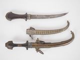 trois types d'armes différents sont exposés sur une surface blanche
