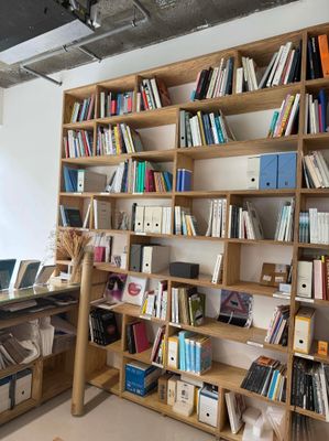 a desk with a laptop and a bookshelf filled with books