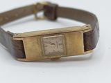 an image of a wrist watch with a leather band and a gold plated case