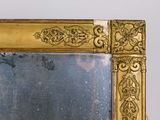 a mirror with a gold frame on a table