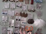 several pairs of earrings are displayed on a wall with price tags