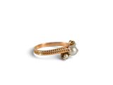 a close up of a gold ring with a pearl on it