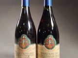 two bottles of red wine sitting next to each other on a table