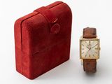 a small red box with a watch next to it