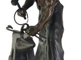 bronze statue of a man with a hammer on a rock