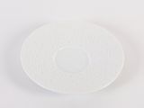 a white plate on a white surface with a small white object in the middle of it