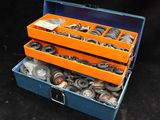 une boîte à outils orange et bleue remplie de pièces métalliques diverses