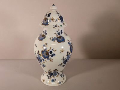 un vase blanc orné de fleurs bleues, posé sur une table