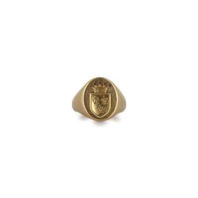 un gros plan d'une bague en or ornée d'un blason