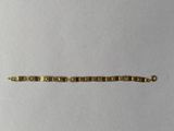 gros plan d'un bracelet en or sur une surface blanche