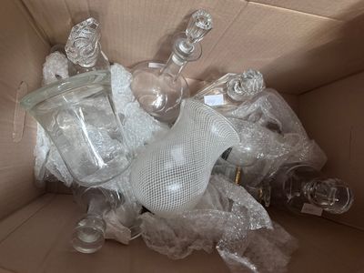 une boîte remplie de bouteilles en verre vides et un sac en filet