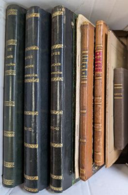 several old books are lined up in a row on a shelf