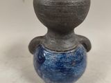 a small blue vase sitting on a white surface