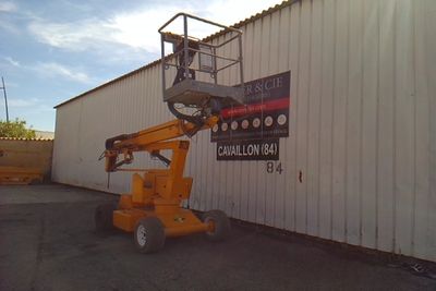 a picture of a man on a scissor in front of a building