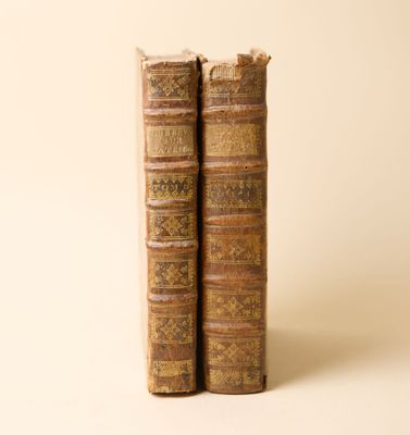 deux vieux livres posés l'un sur l'autre sur une surface blanche