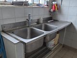 deux éviers dans une cuisine, avec une fenêtre en arrière-plan