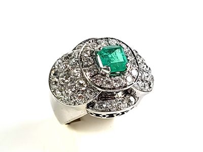 une image représentant une bague sertie d'un diamant et d'une émeraude sur fond blanc