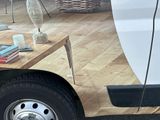a white truck parked in a parking lot with a coffee table on the side of the truck