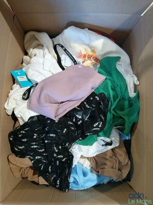 a box full of clothes that is sitting on the floor