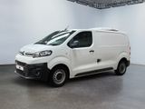 La camionnette blanche est garée dans la grande salle du bâtiment.