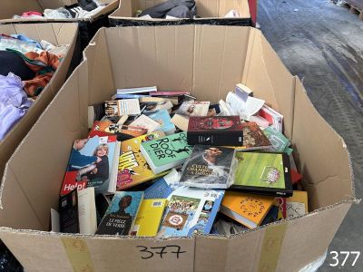 de nombreux livres dans un carton posé dans la rue