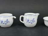 four pieces of blue and white porcelain tea set on a black surface