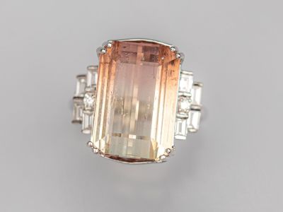un gros plan d'une bague ornée d'une pierre orange entourée de diamants blancs