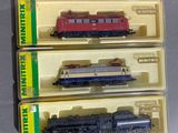 trois petits trains qui se trouvent dans une boîte posée sur la table