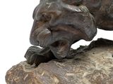 a statue of a cat on a rock with a mouse in it ' s mouth