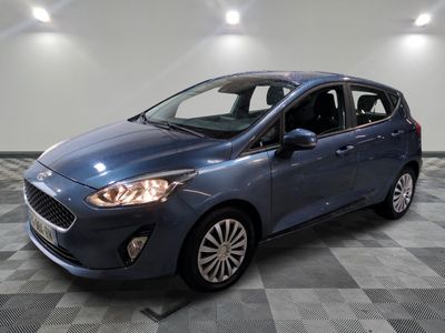 une Ford Fiesta bleue garée dans une pièce au sol carrelé