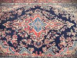 an antique persian rug with a blue background and a red border