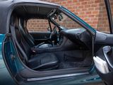 a blue car with its door open sitting in front of a brick wall