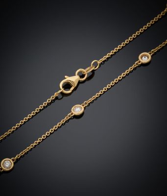 une paire de bracelets à chaîne en or sertis de diamants sur fond noir