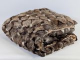 une couverture marron et blanche posée sur une surface blanche