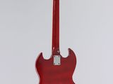 a red electric guitar hanging from a white wall