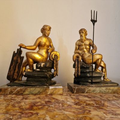 deux statues représentant un homme et une femme assis sur une table en marbre