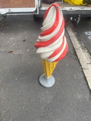 an ice cream cone on top of a cone on the street
