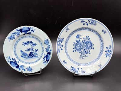 pair of blue and white plates with flowers on them sitting on a table