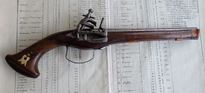 un vieux pistolet posé sur un livre, sur une table