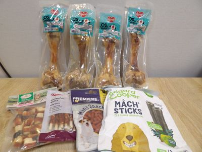 cinq sachets de friandises pour chiens et un sachet de friandises pour chiens posés sur une table