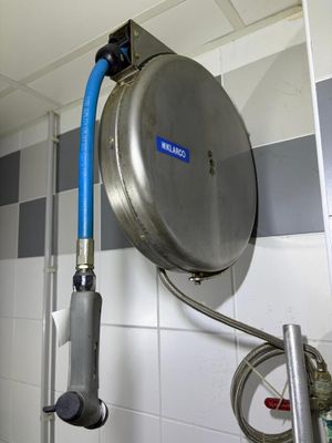 a blue hose attached to a wall in a bathroom