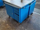 a blue table with a machine on it in a warehouse