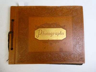 un vieux livre en cuir marron sur lequel est posé un stylo