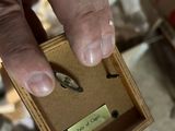 a person holding a small wooden box with a coin in it