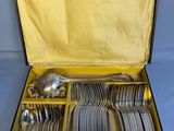 a box with silverware in it on a blue surface