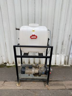 a white tank sitting on a metal cart on the side of the road