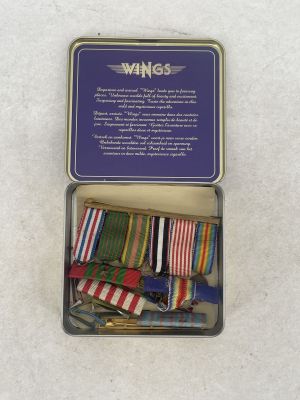 a small tin with a bunch of ribbons in it