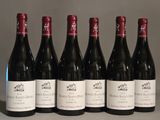 six bouteilles de vin rouge sont alignées sur une table